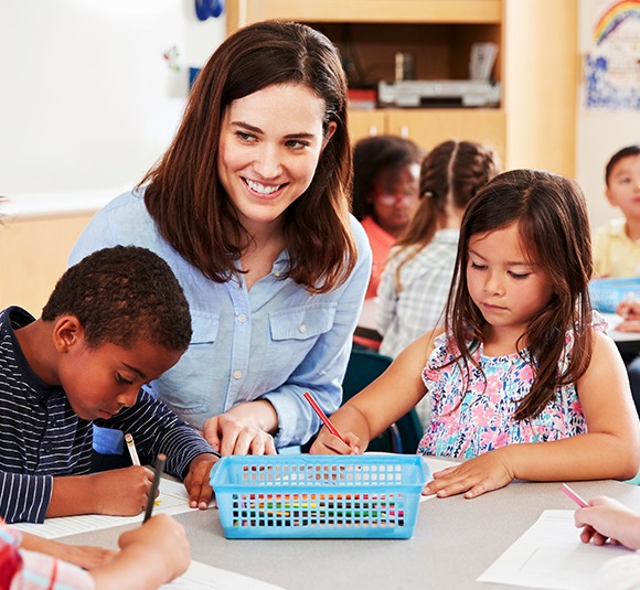 Professora de inglês interagindo com alunos na sala de aula
